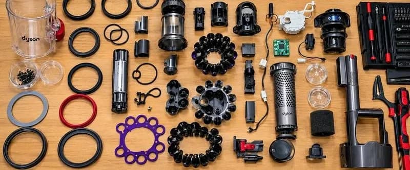 Детали аккумуляторного пылесоса Dyson, уплотнители и инструменты на рабочем столе